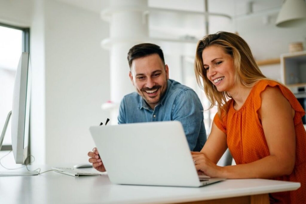 a man and a woman looking at a laptop
