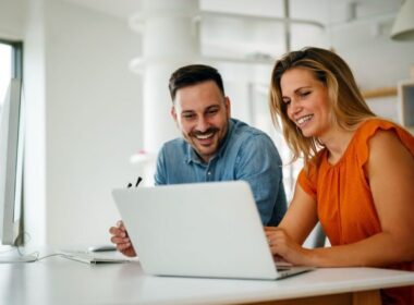 a man and a woman looking at a laptop