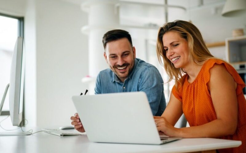 a man and a woman looking at a laptop