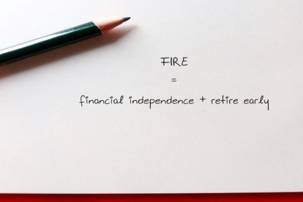 a pen on a piece of paper that says FIRE - financial independence + retire early