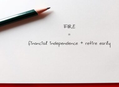 a pen on a piece of paper that says FIRE - financial independence + retire early