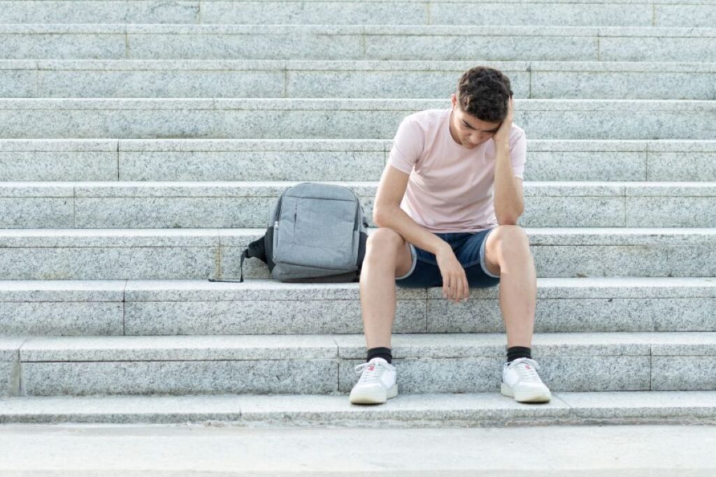 a teenager looks worried on some steps
