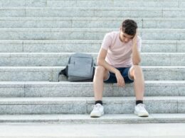a teenager looks worried on some steps
