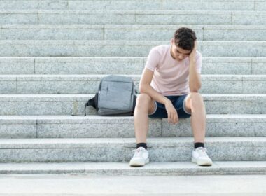 a teenager looks worried on some steps
