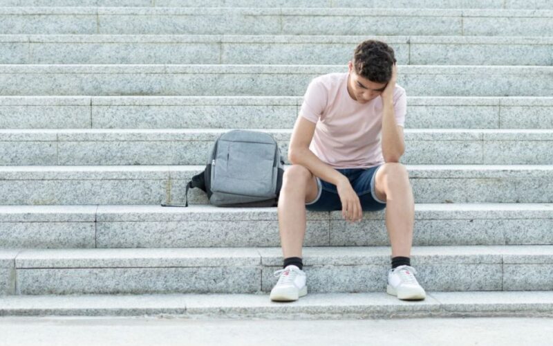 a teenager looks worried on some steps