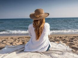 a woman on a beach looking out to sea
