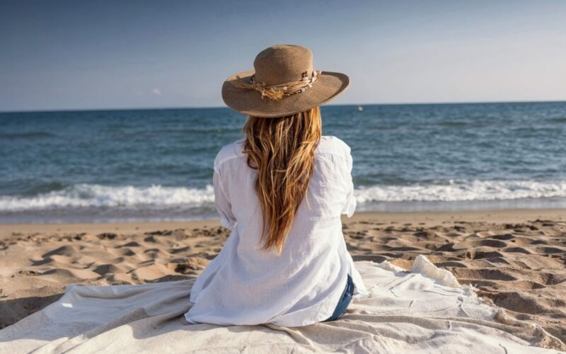 a woman on a beach looking out to sea
