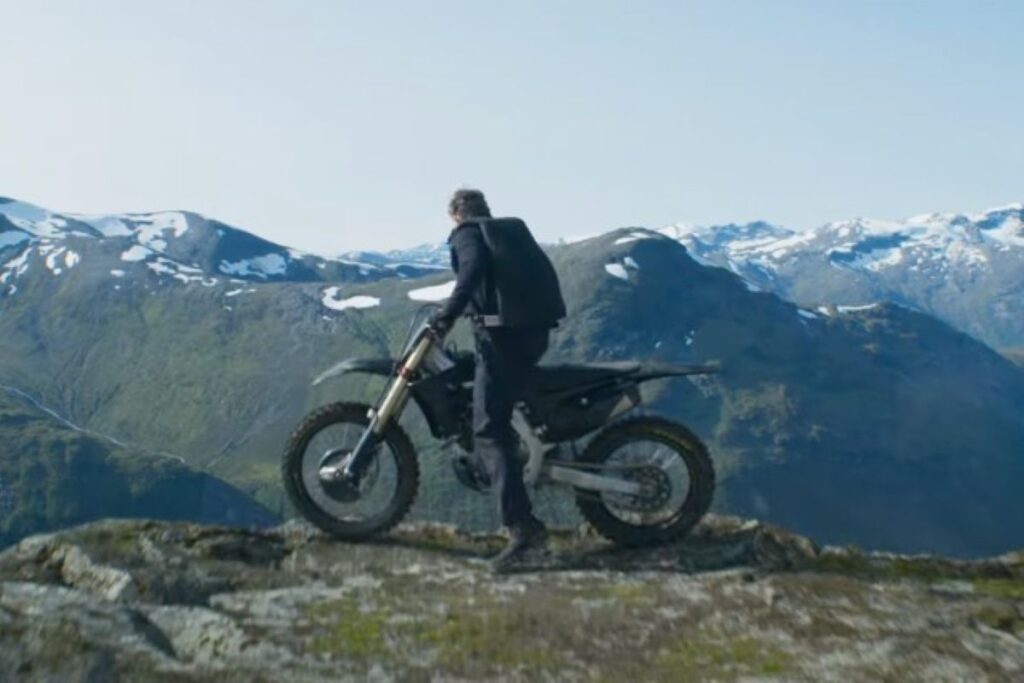 A man on a motorbike on a mountain top.
