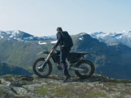 A man on a motorbike on a mountain top.