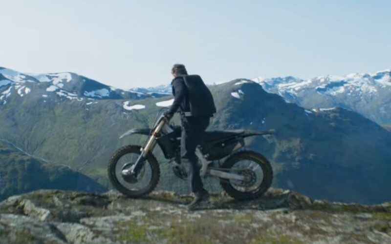 A man on a motorbike on a mountain top.