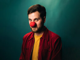A man wearing a comedy red nose