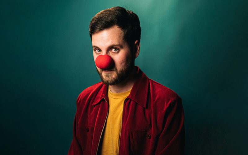 A man wearing a comedy red nose
