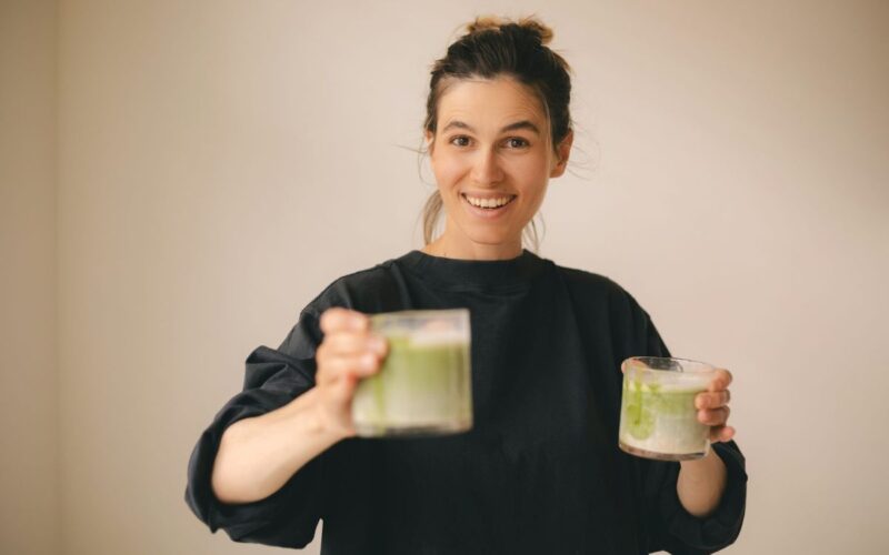 A woman with two glasses of matcha
