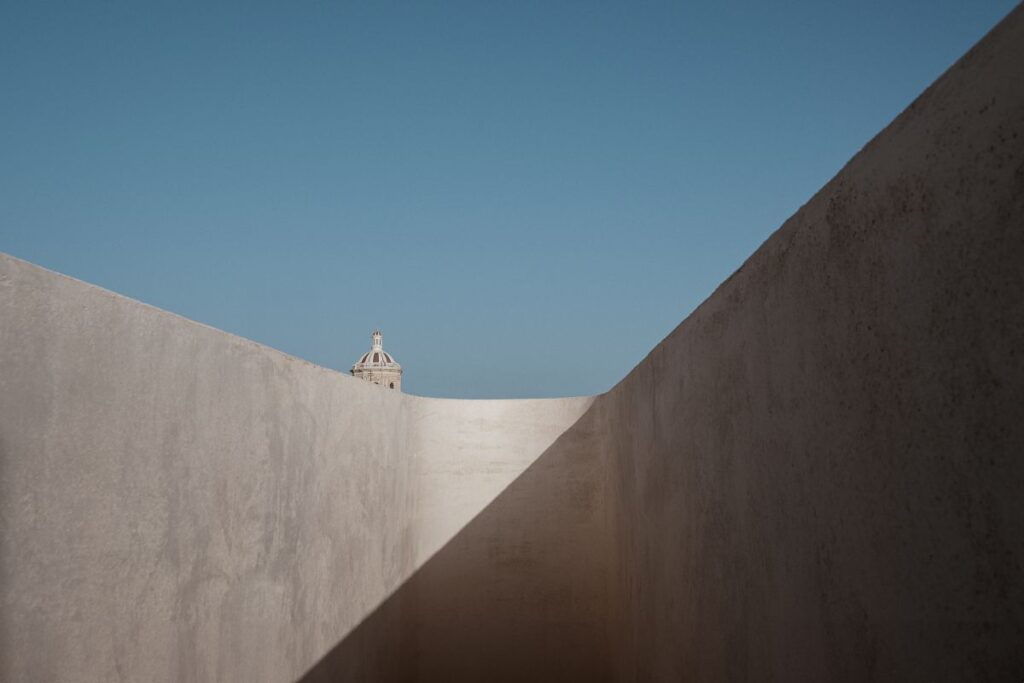 A smooth wall with a cupola beyond