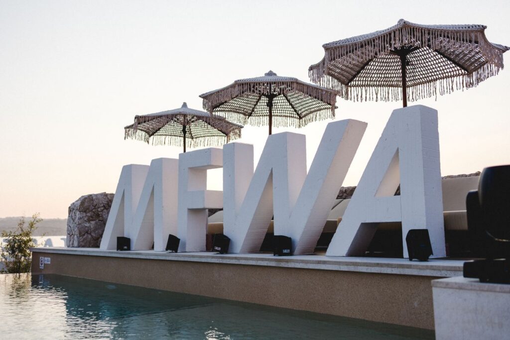 A giant MFWA 2025 logo by a pool