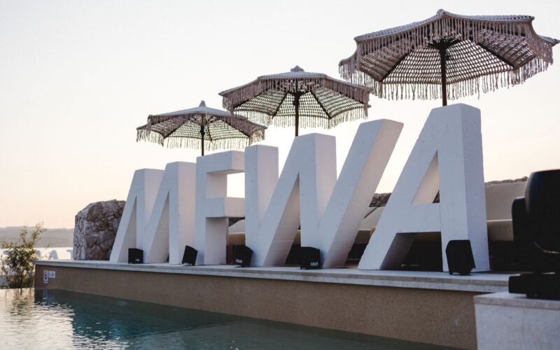 A giant MFWA 2025 logo by a pool