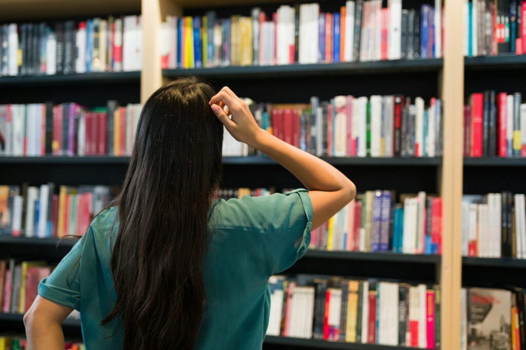 a woman looking at shelves of books