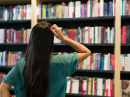 a woman looking at shelves of books