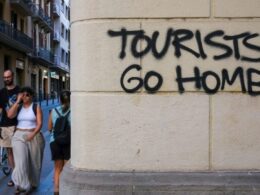 An image of graffitti in Barcelona saying Tourists Go Home