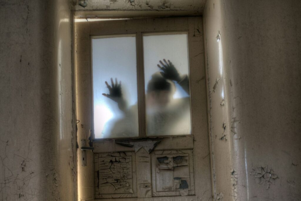 the shadowy figure of a man at a door