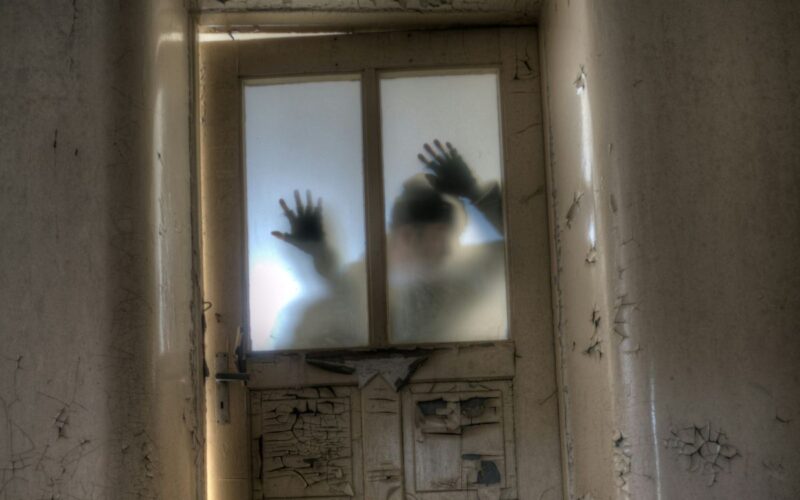 the shadowy figure of a man at a door