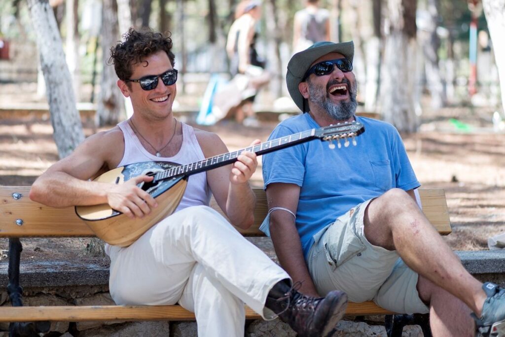 Two men laughing on a bench