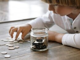 A child and a jam jar of coins