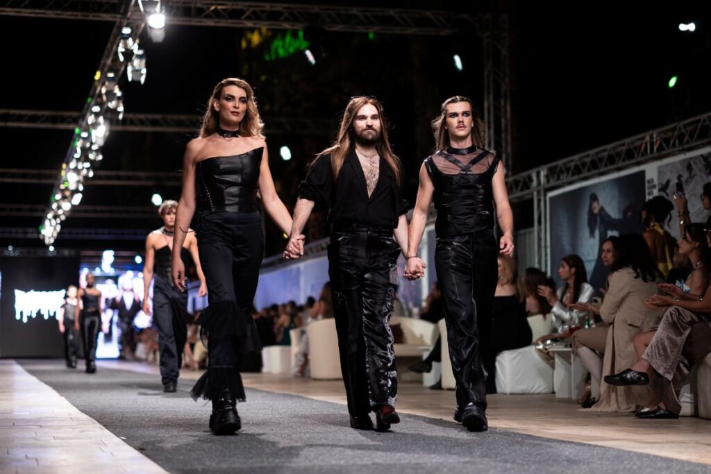 Three models in black on a catwalk