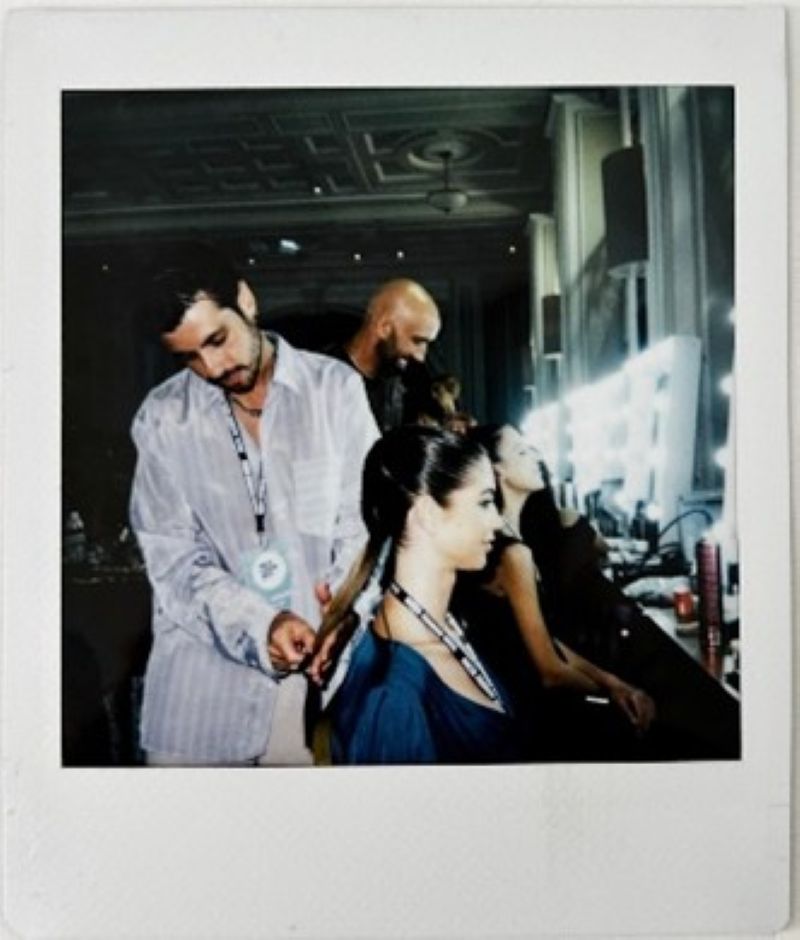 A photo of backstage with a hairstylist and model for Charles & Ron