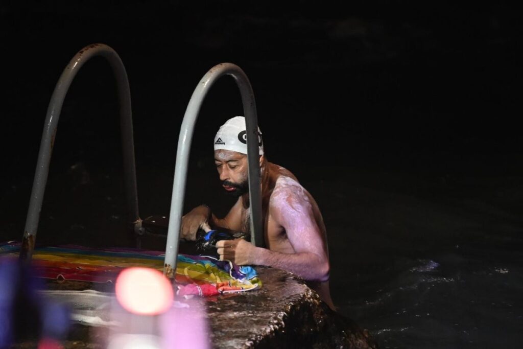 Neil Agius climbs a ladder at Għar Lapsi in the dark