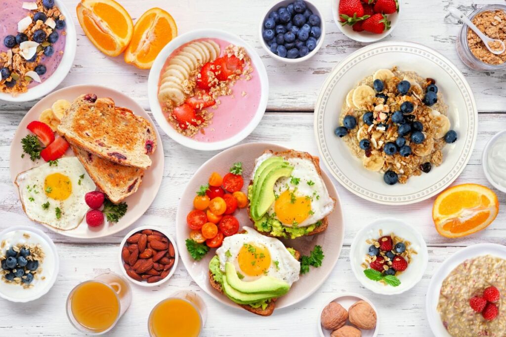Many plates of healthy-looking food in bright colours