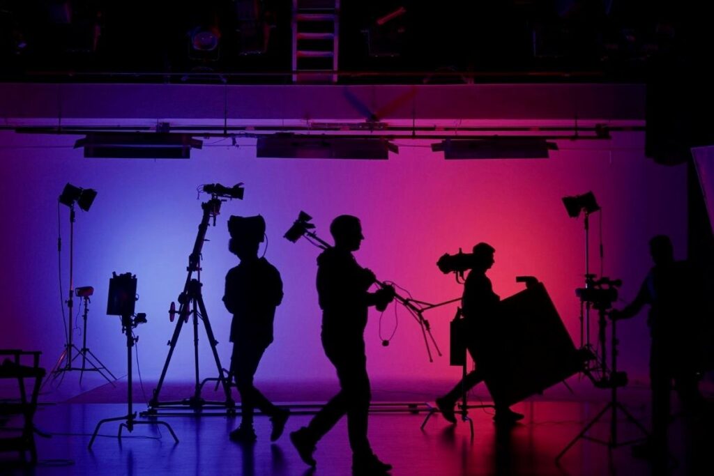 Silouettes of people beahind the scenes on a stage set