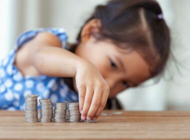 a child lining up piles of coins