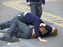 Two boys fighting in a school playground