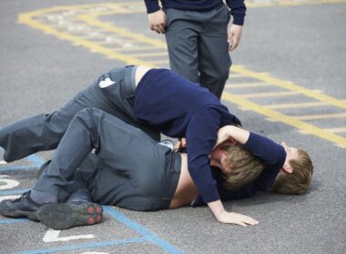 Two boys fighting in a school playground