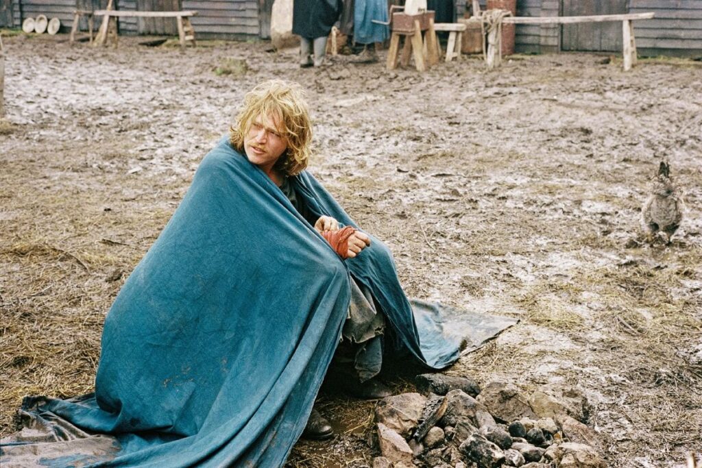 a man sits on the muddy ground