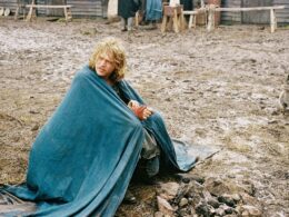a man sits on the muddy ground