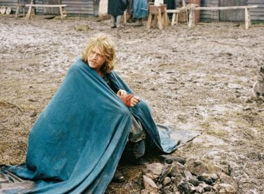 a man sits on the muddy ground