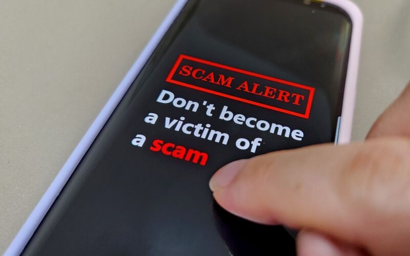 a phone screen reading SCAM ALERT