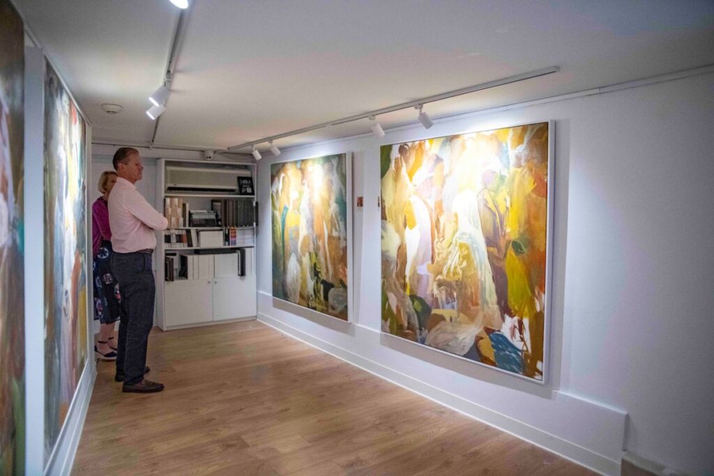 Couple looking at works by Alexander Tadesse at the gallery