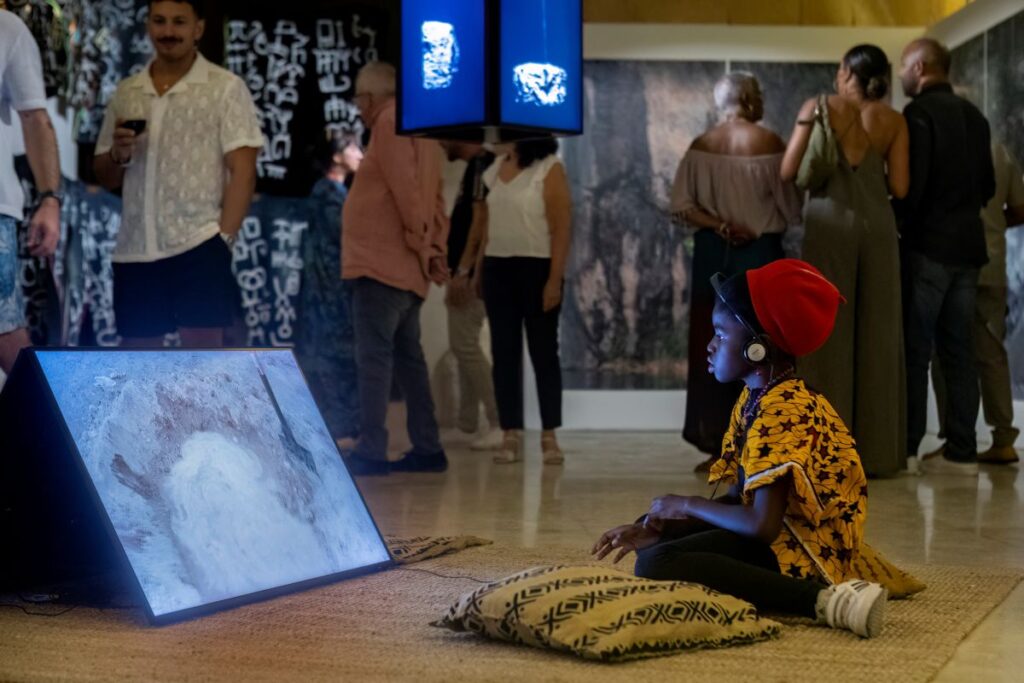 Girl watches Rural Futurisms video Building the Hut-Lab in Makgobistad. Photo by Elisa von Brockdorff