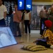 Girl watches Rural Futurisms video Building the Hut-Lab in Makgobistad. Photo by Elisa von Brockdorff