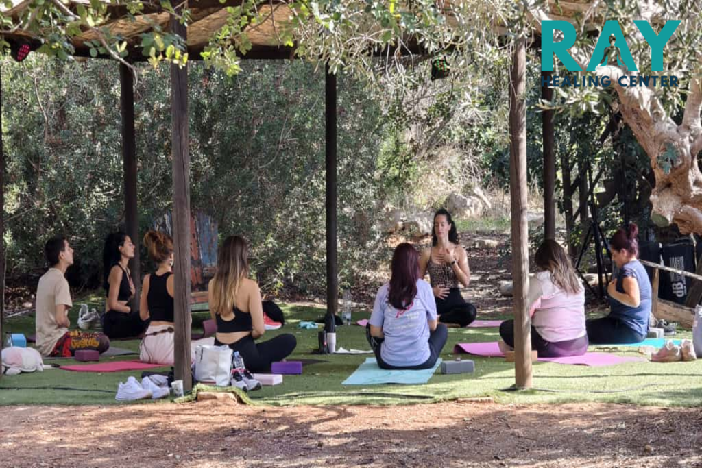 people sitting on mats amongst trees