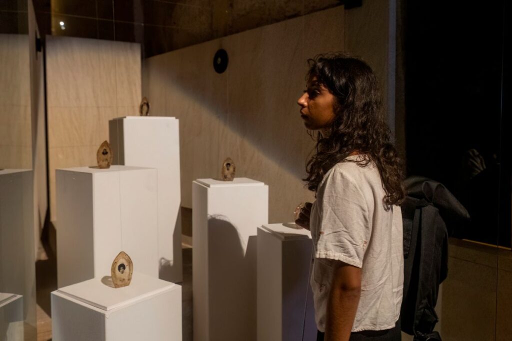 Woman looking at Miriam Hillawi Abraham's work Adbar Offerings to the Unseen World. Photo by Elisa von Brockdorff