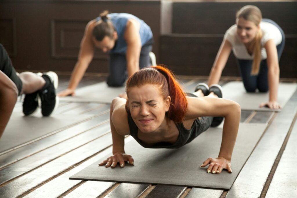 A woman grimacing in an exercise class