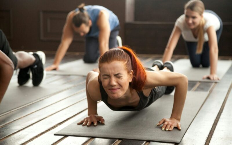A woman grimacing in an exercise class