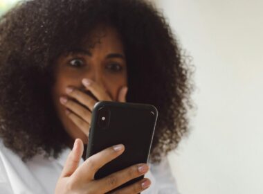 A woman looks shocked as she looks at her phone